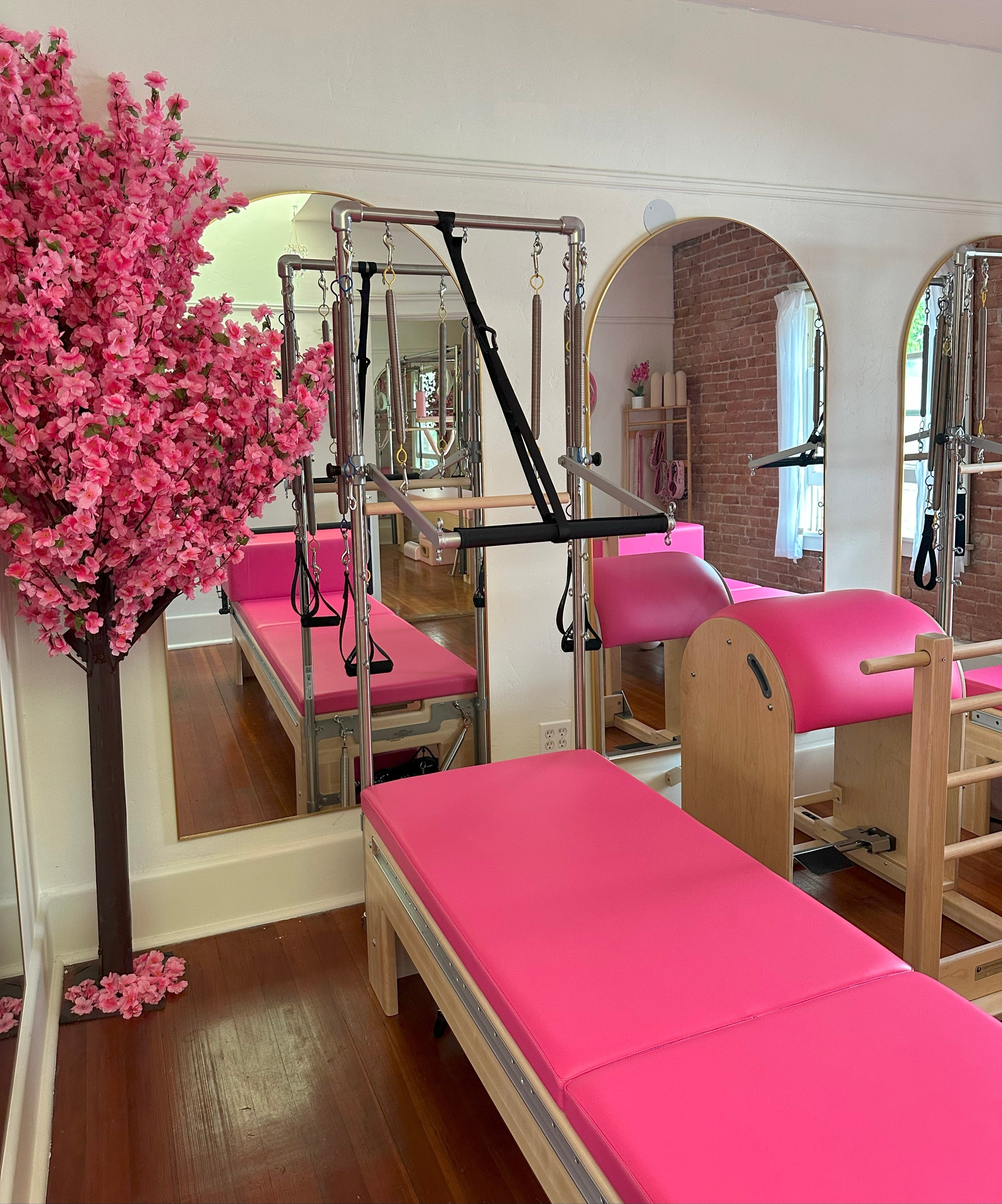 Pilates Barbie Pink reformer with Tower and Mat in a boutique studio setting.